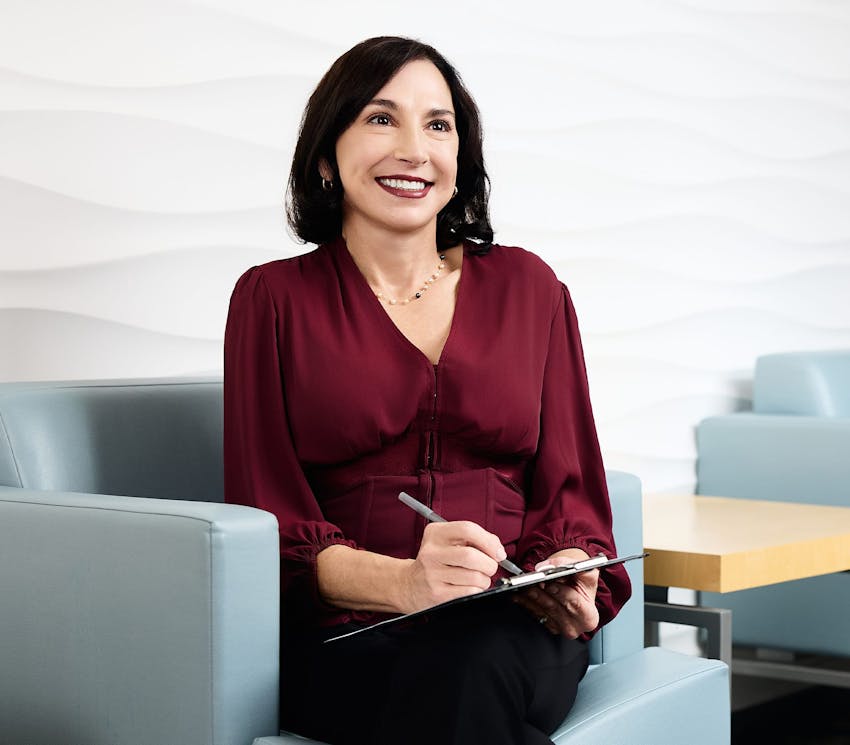 woman sitting in seat filling out form on clipboard