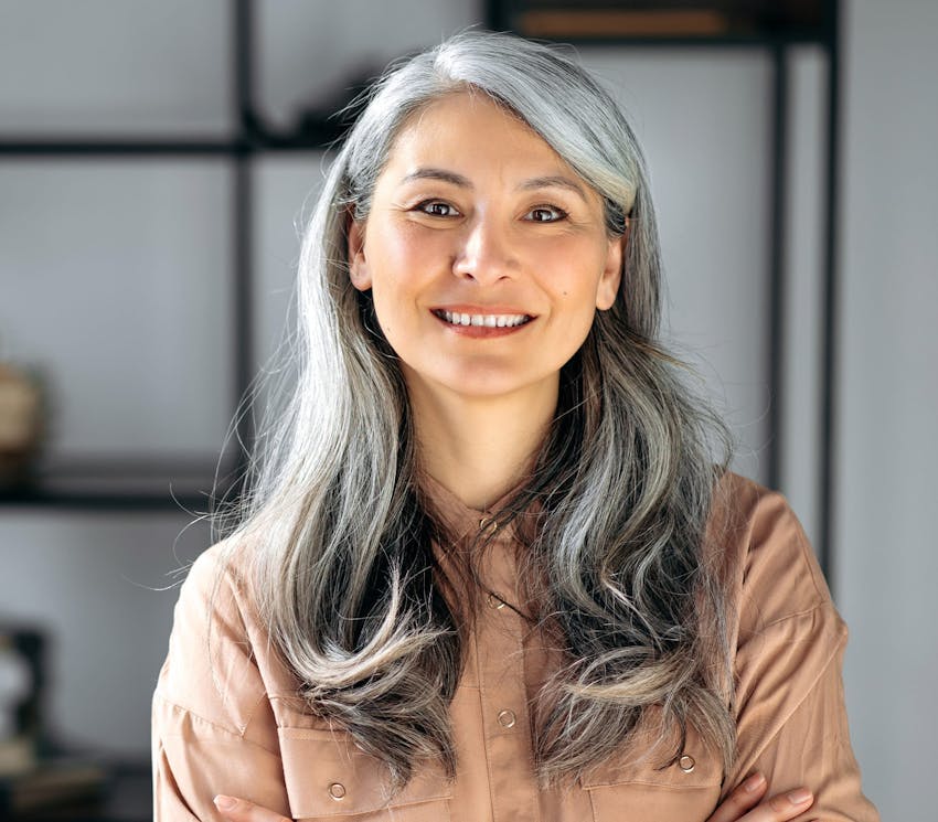 older woman in brown shirt smiling forward