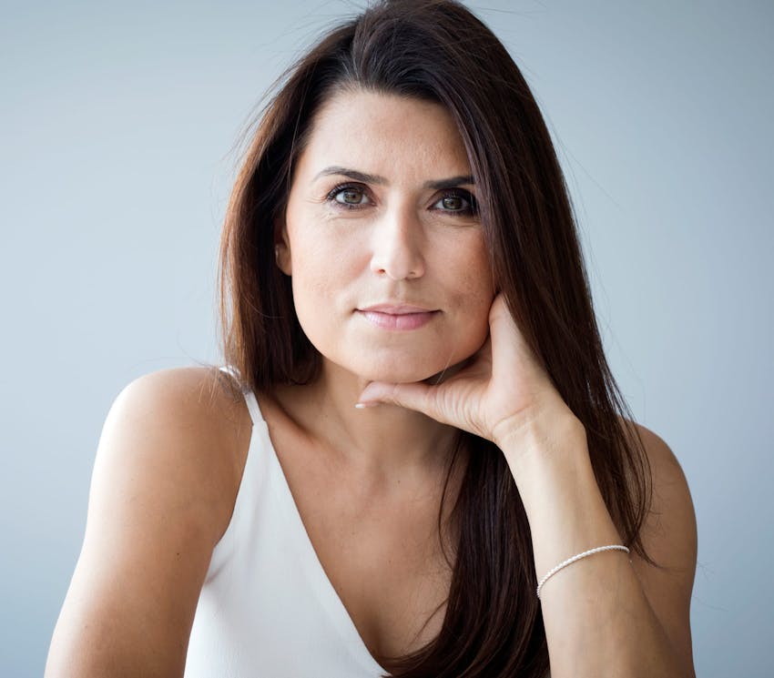 woman leaning on table with her hand on her jaw
