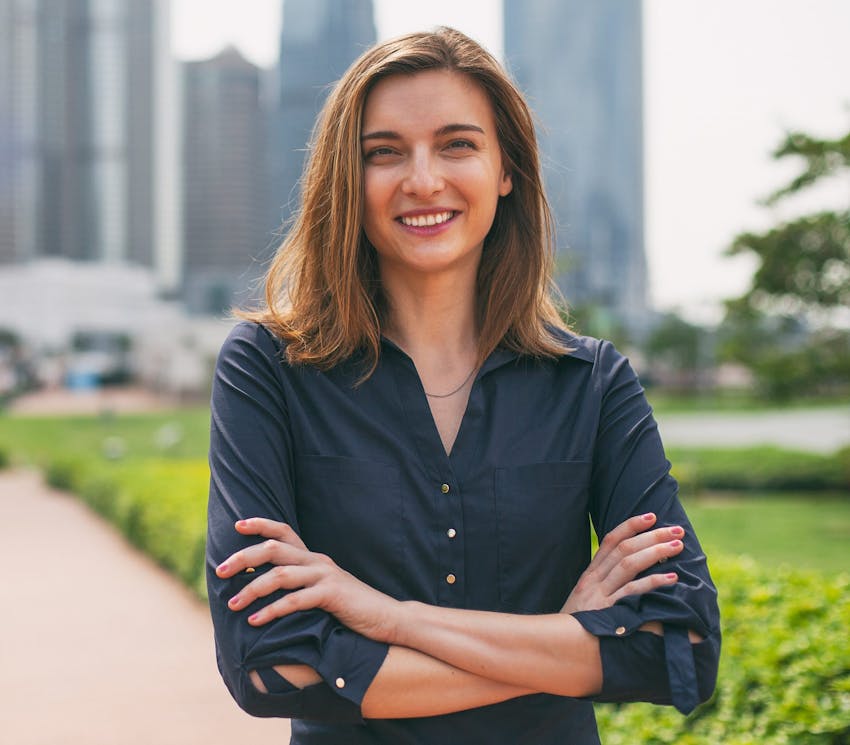 woman smiling outside with her arms crossed