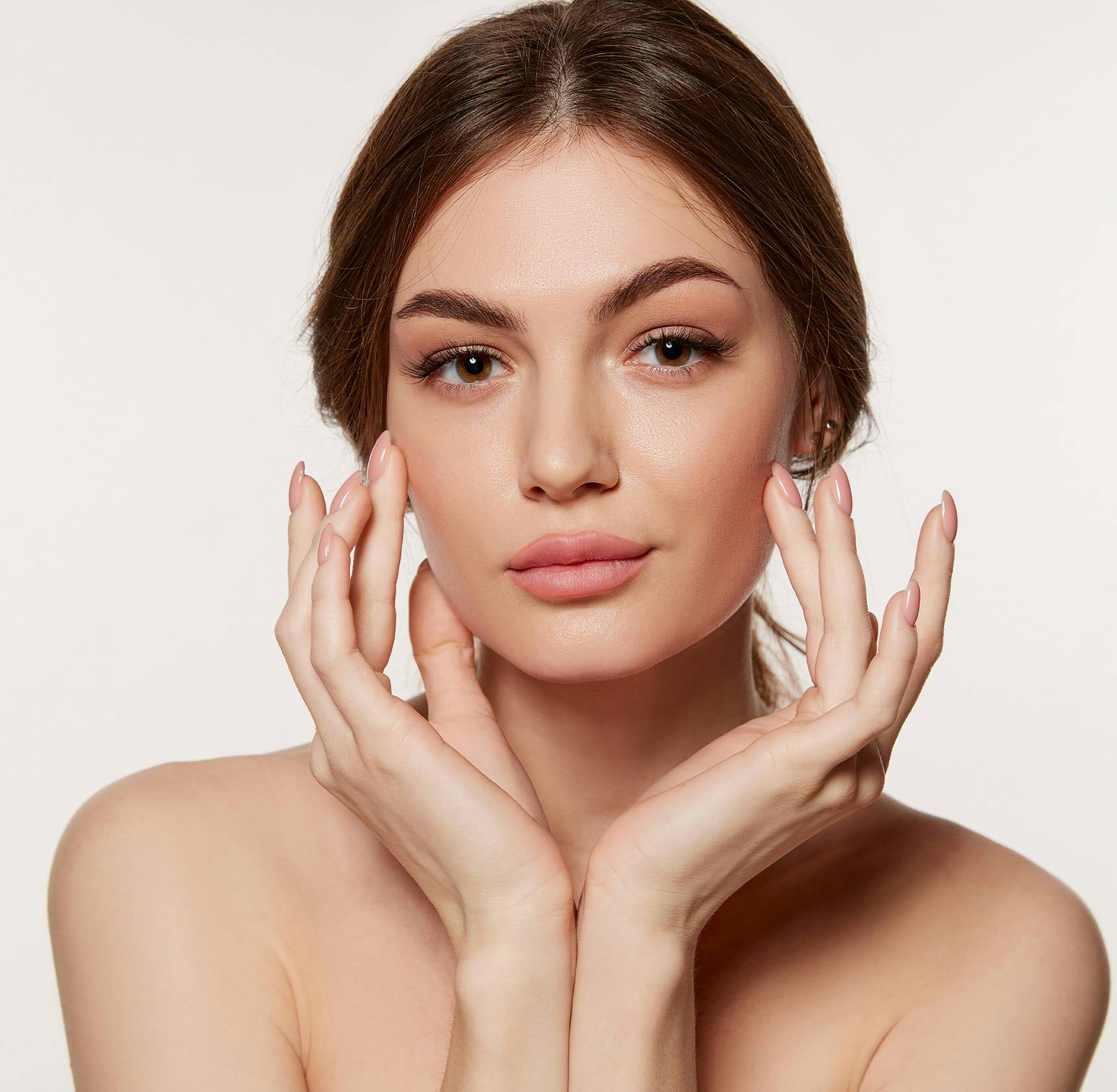 woman looking forward with her hands around her face