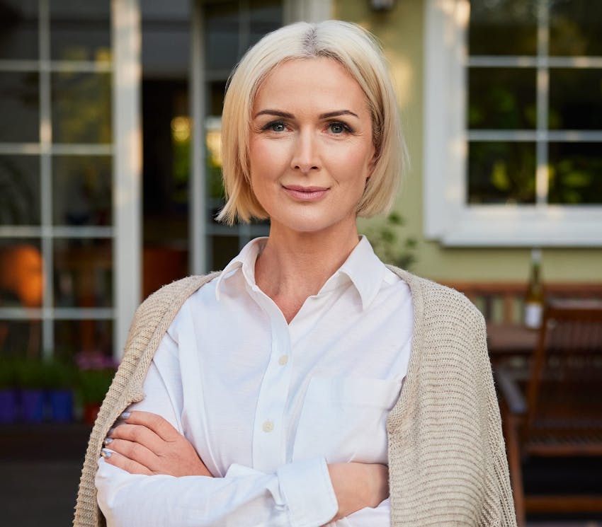 woman with short blonde hair with her arms crossed