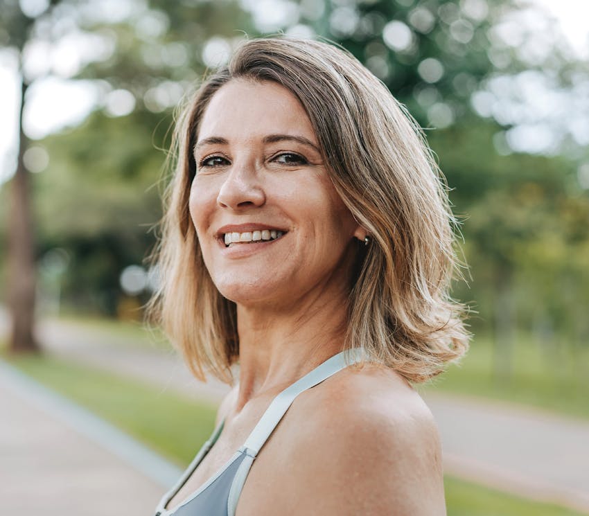woman outside facing to the side and smiling