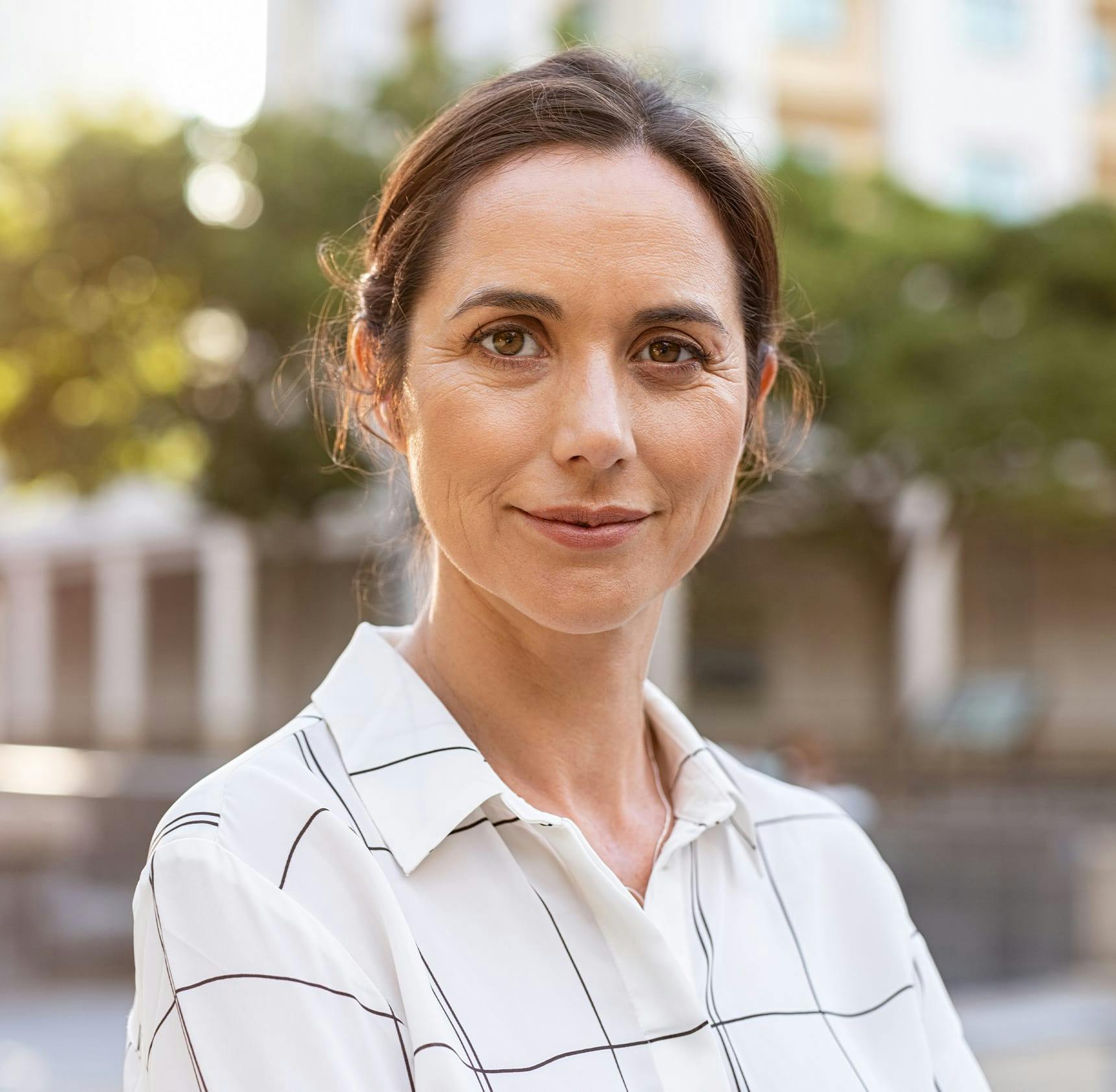 woman outdoors looking forward and smiling
