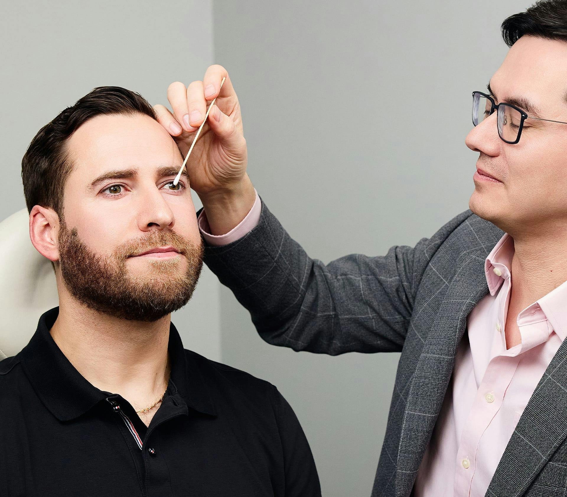 doctor looking at client's bridge on his nose