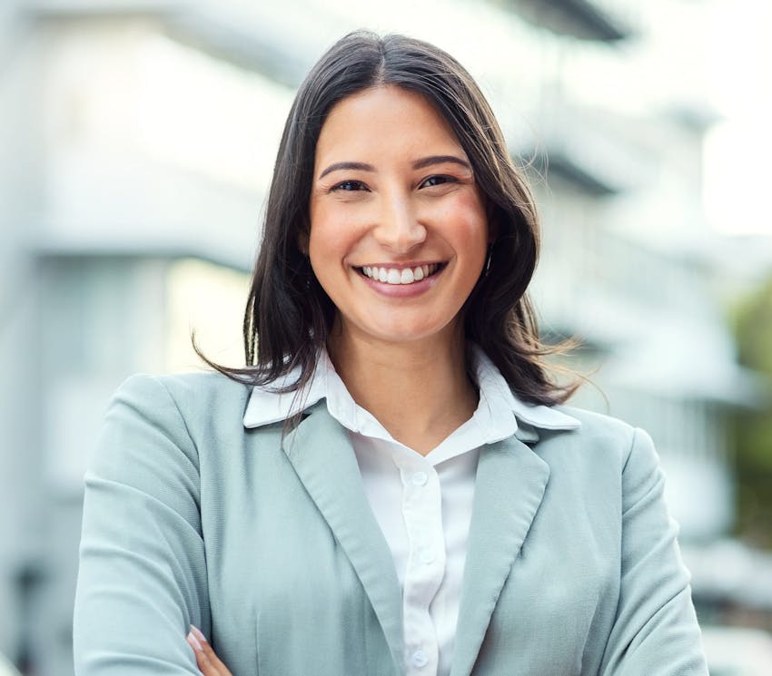 woman smiling in blue suit jacket with her arms crossed
