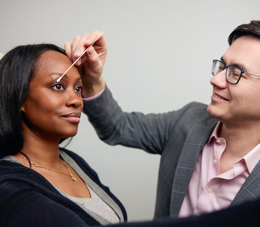 woman getting her eyelids checked by doctor