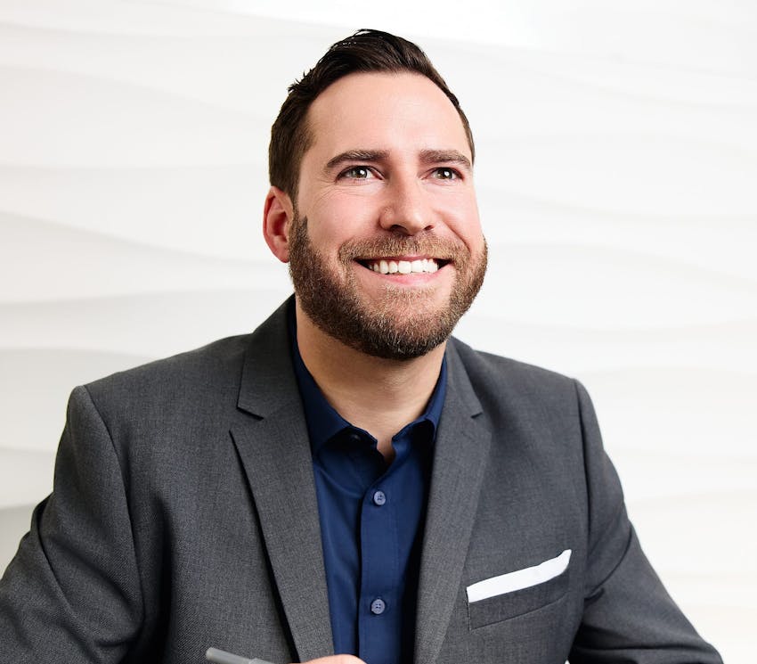 man in gray suit smiling