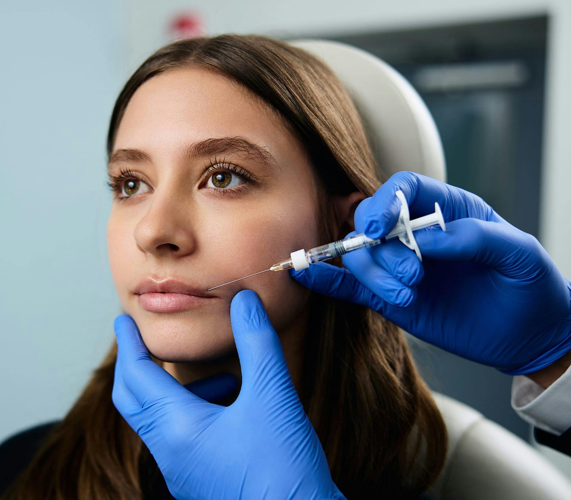 female patient getting injection in her upper lip
