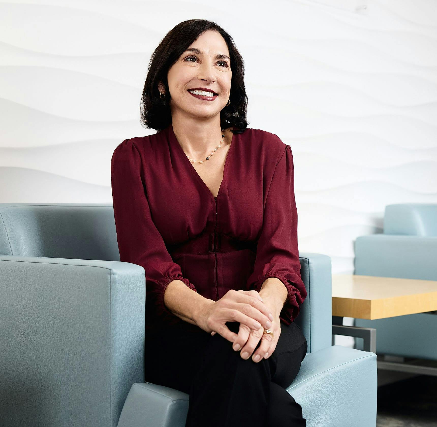 female patient sitting in waiting room and smiling