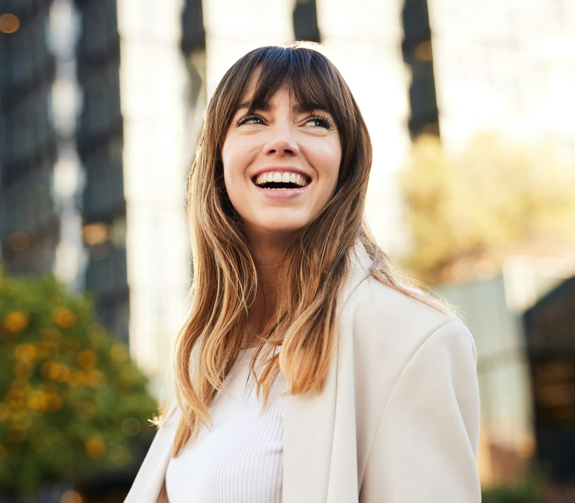 woman with bangs outside smiling