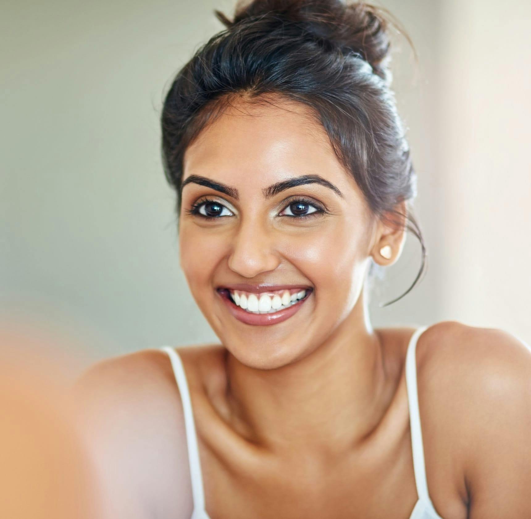 woman with hair tied up and smiling