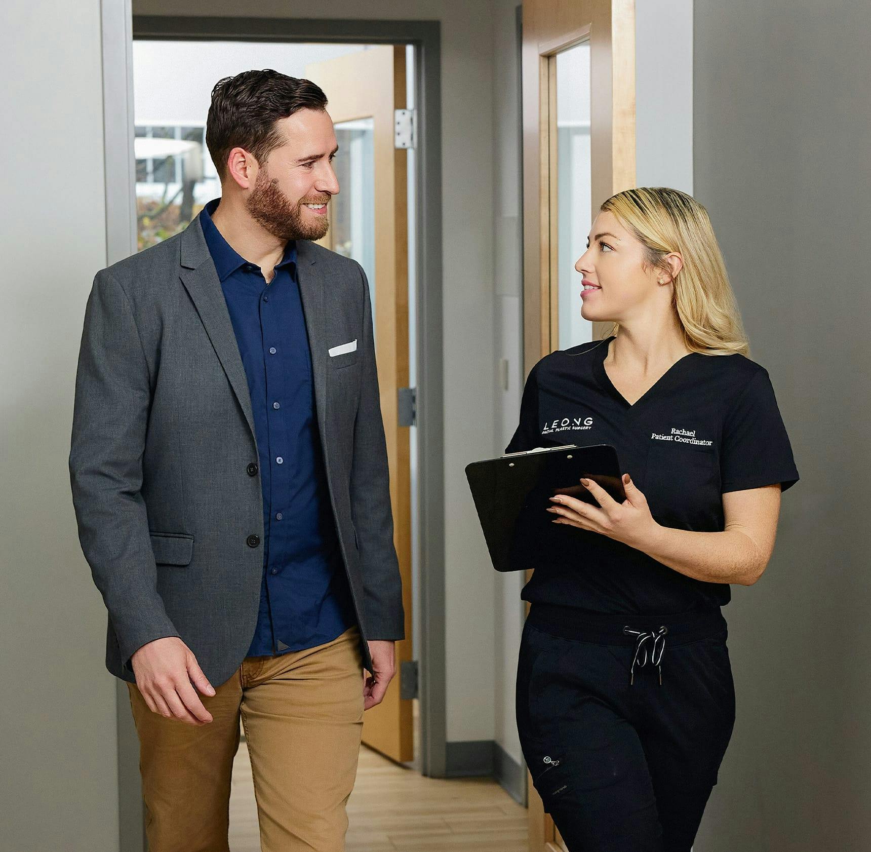 male patient walking in hallway with Leong staff