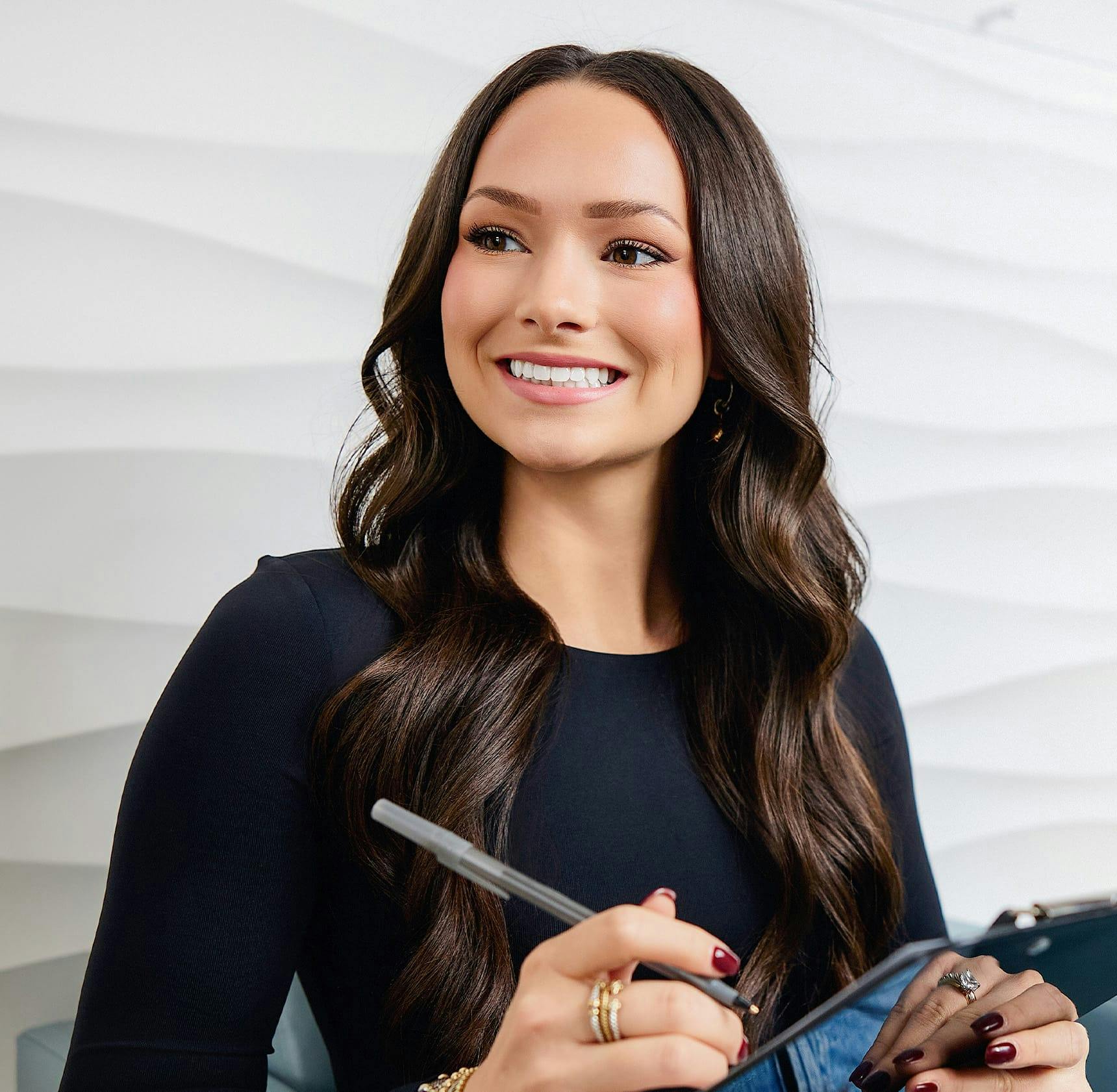 female patient filling out form and smiling