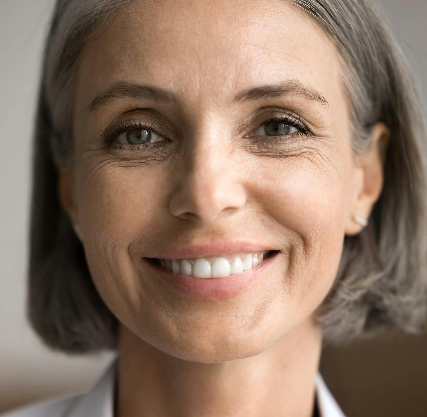 close up on woman with short hair smiling forward
