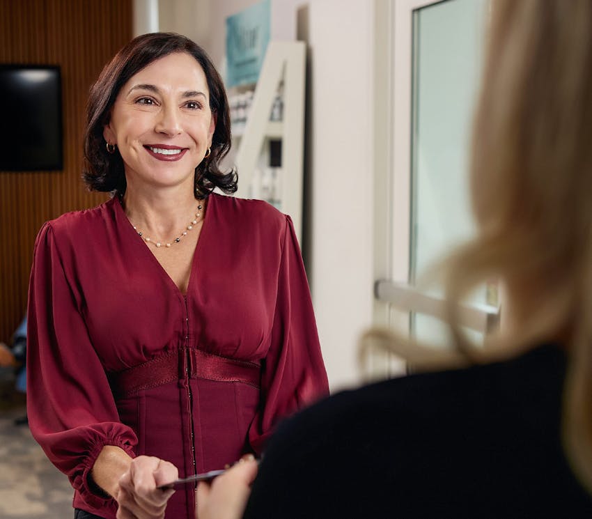 female patient sitting across Leong staff member