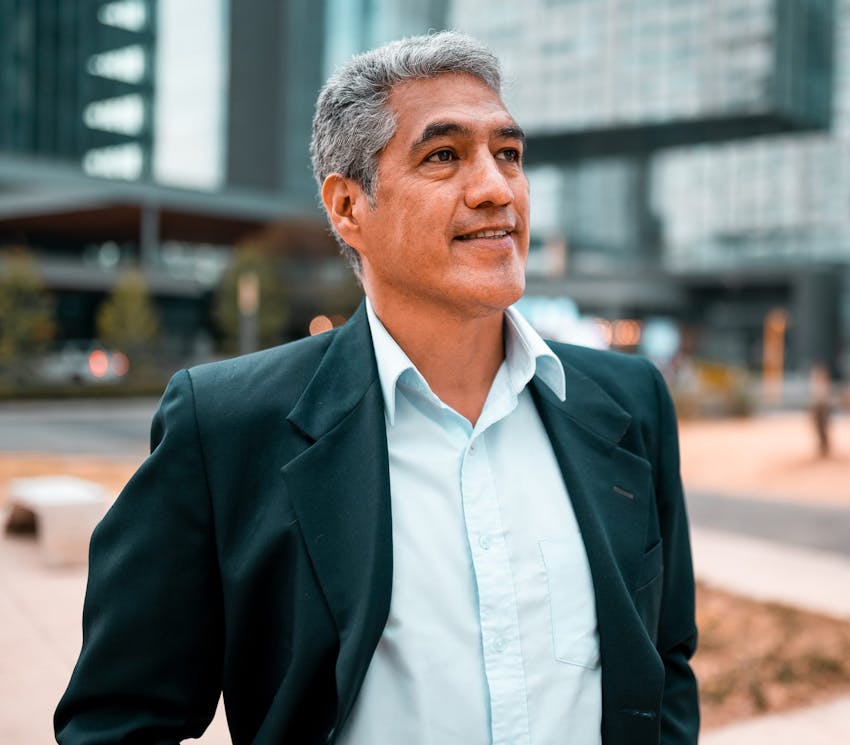 man walking in city with dark green suit jacket on