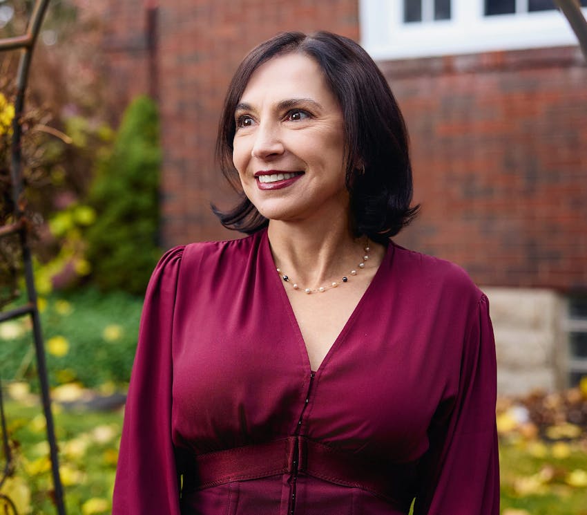 female client smiling outside in maroon dress