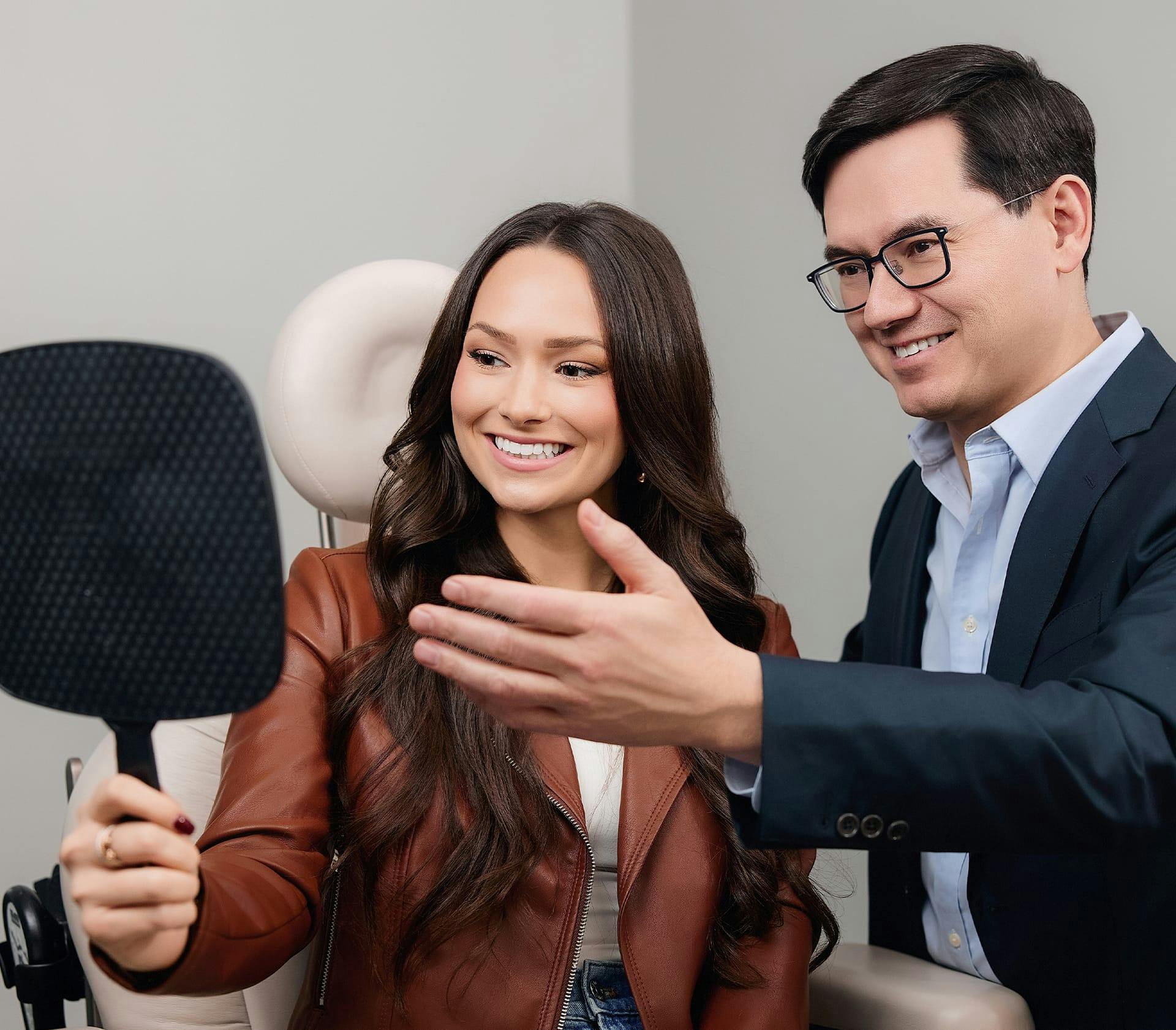 patient looking at her face in mirror with doctor next to her