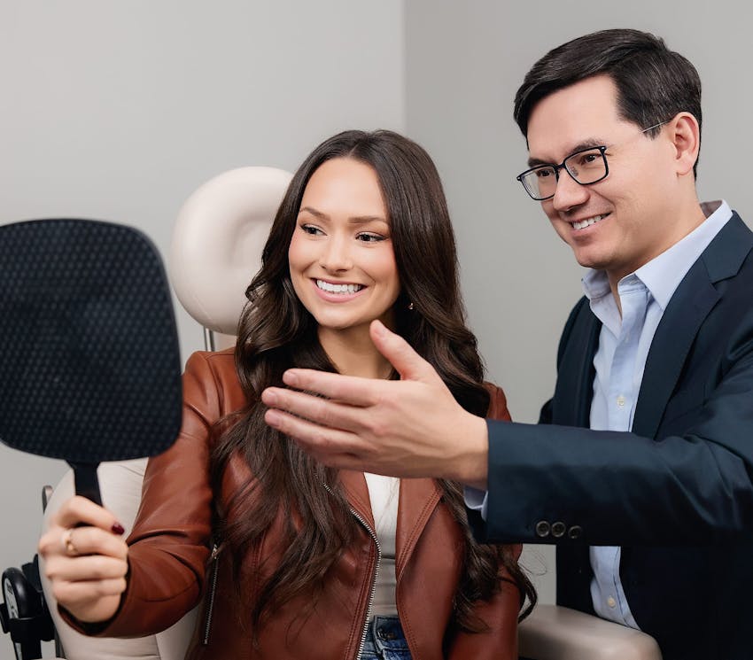 patient looking at her face in mirror with doctor next to her