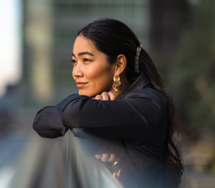 woman smiling and leaning on a railing