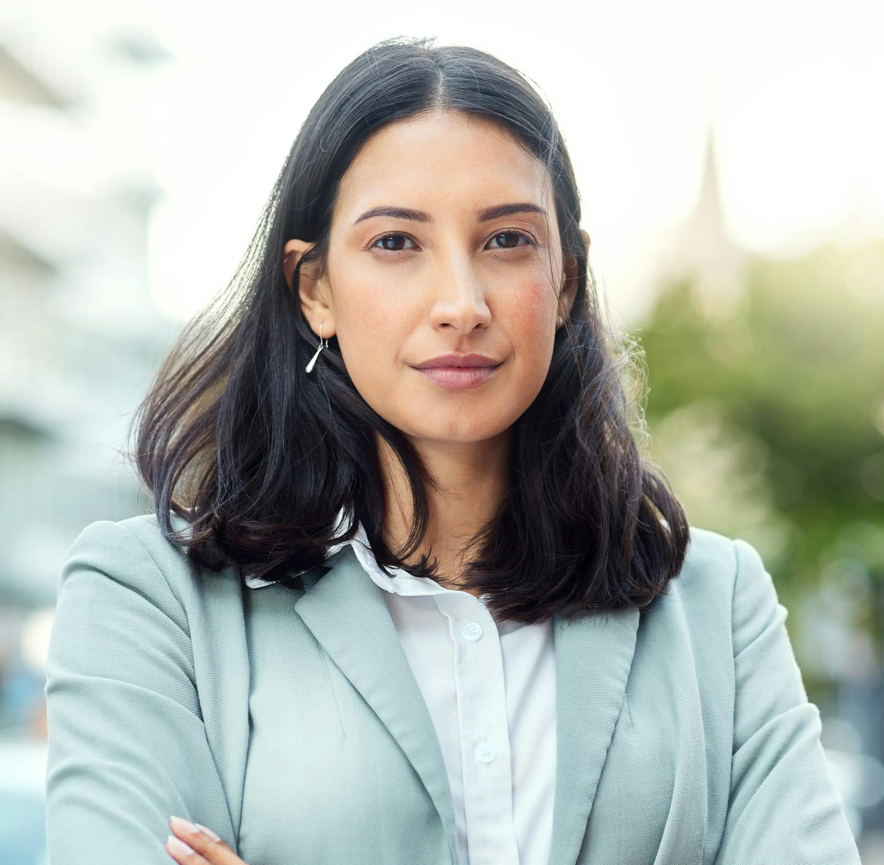 woman with short hair in light blue jacket suit crossing her arms
