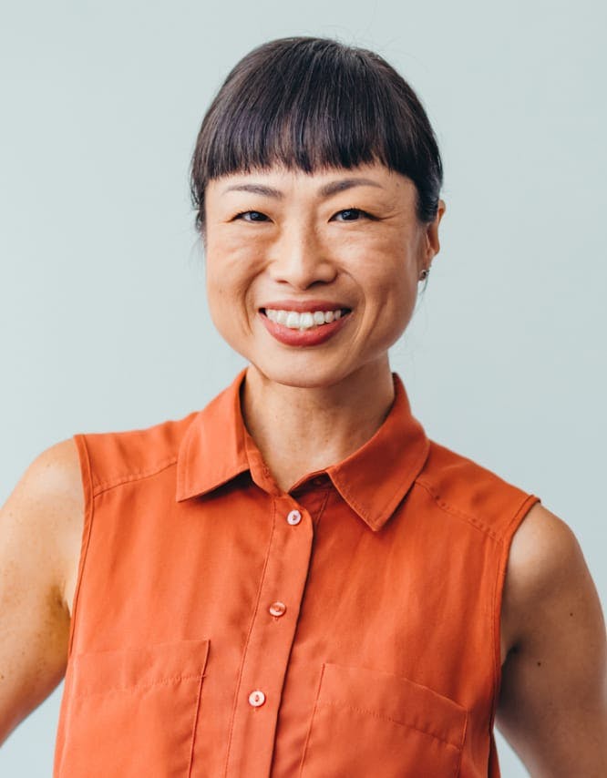 Woman in orange top, smiling