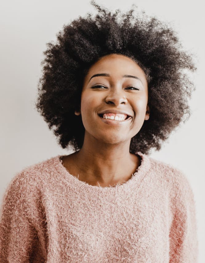 Woman with a pink sweater, smiling