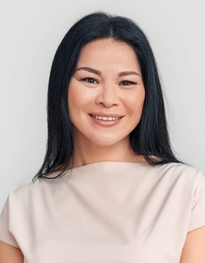 Woman with a beige top, smiling