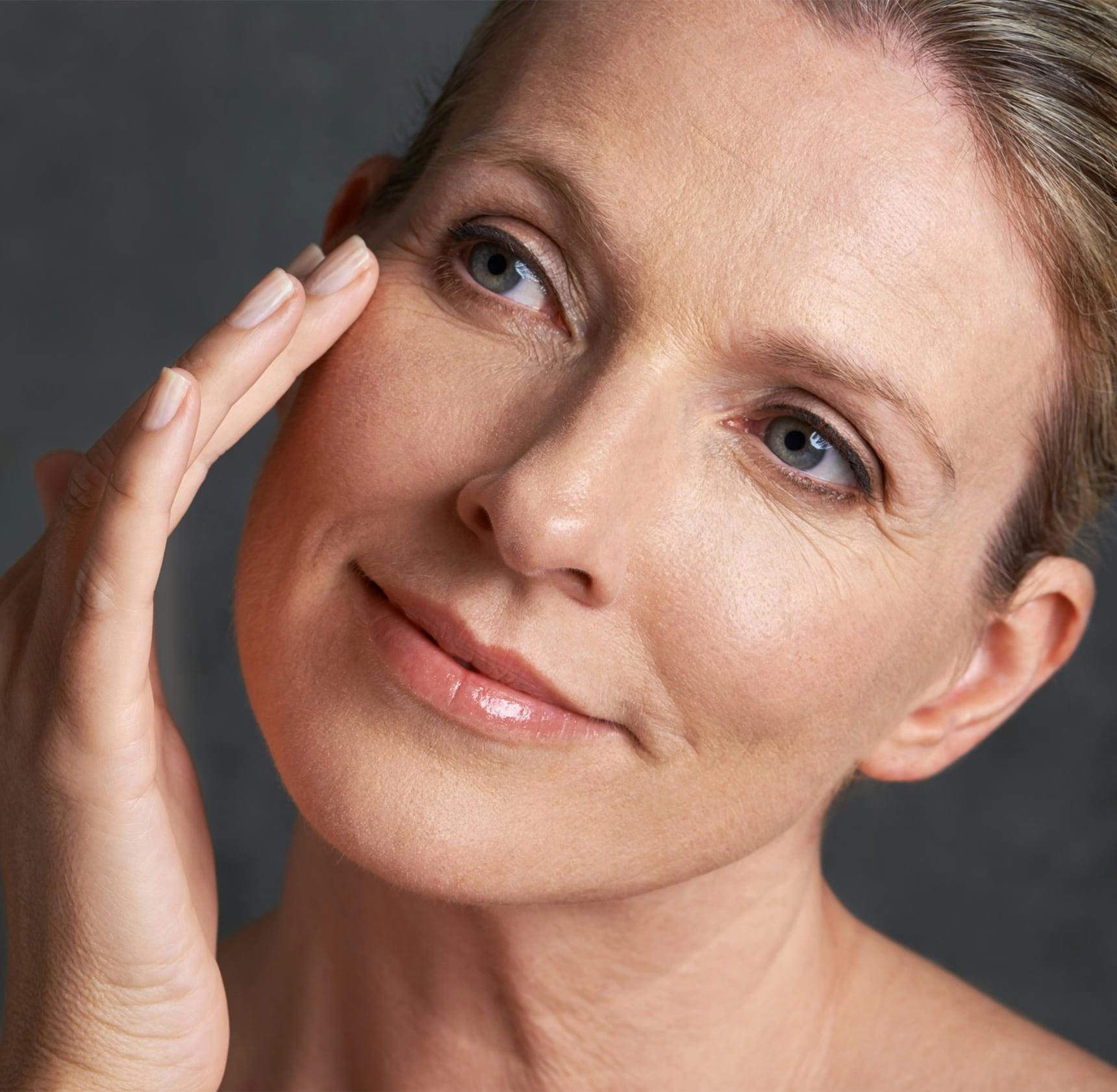 woman smiling with hand on her face