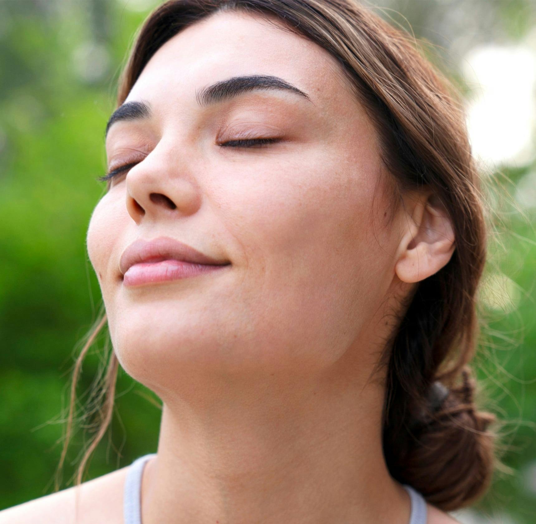 woman smiling with her eyes closed