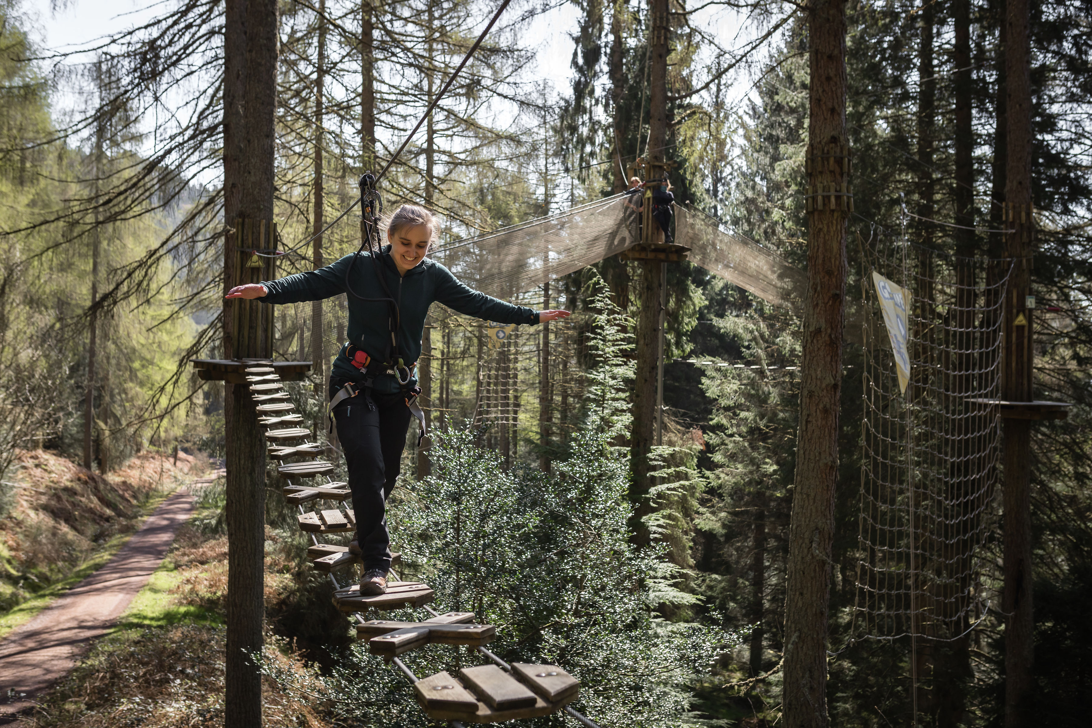Person steps over a high ropes crossing.