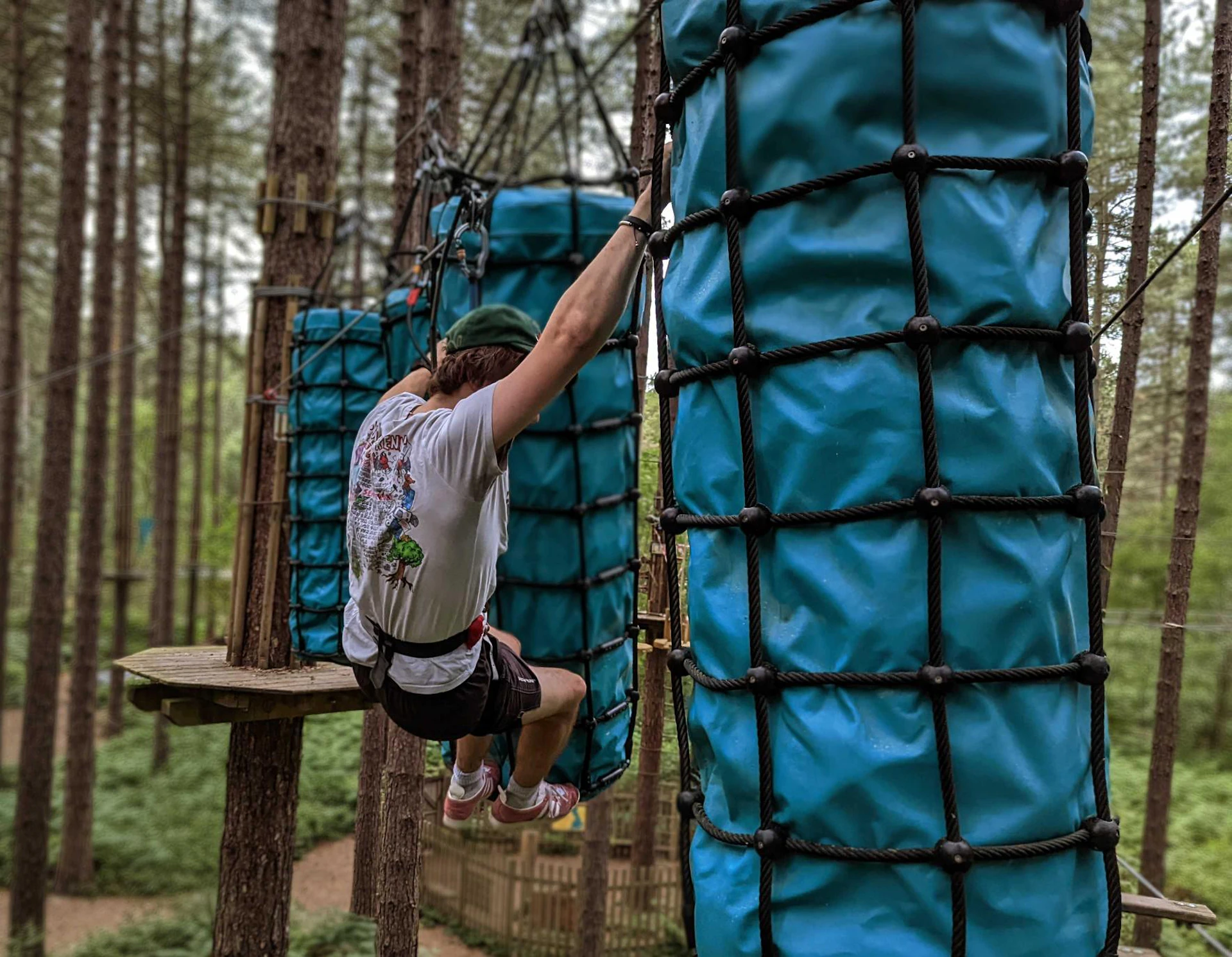 Person crossing a challenging high ropes obstacle.