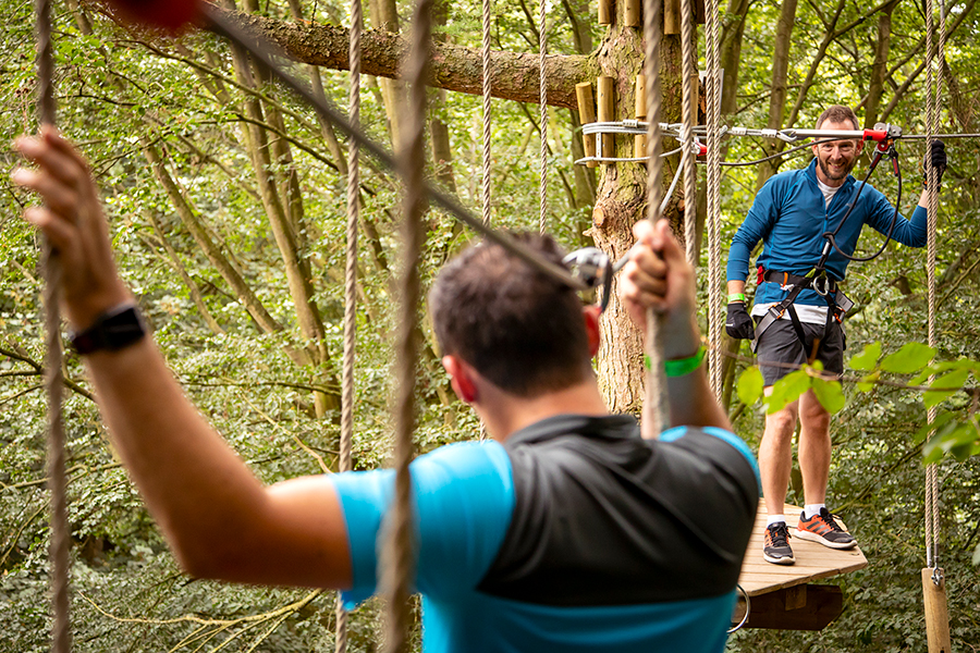 Two people on a high ropes course.
