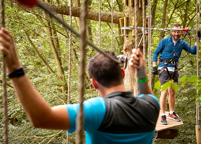 Two people on a high ropes course.