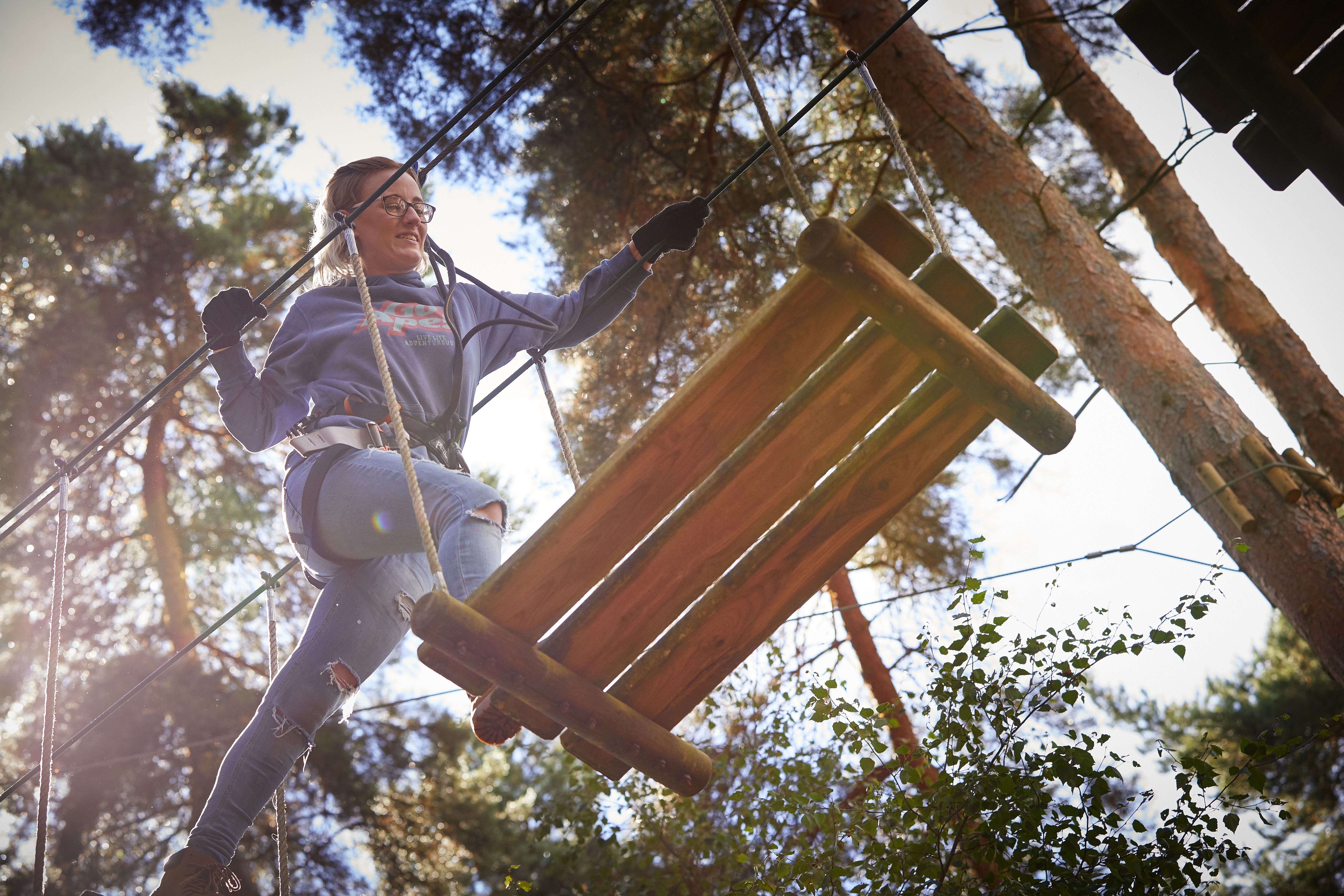 Person above crossing a high ropes obstacle.