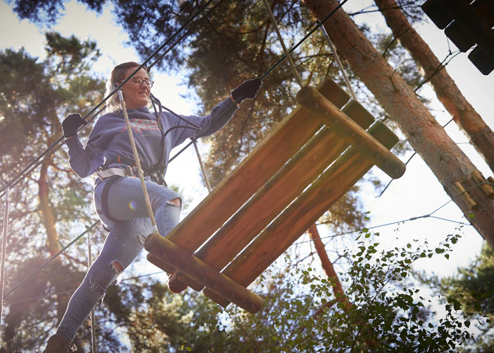 Person above crossing a high ropes obstacle.