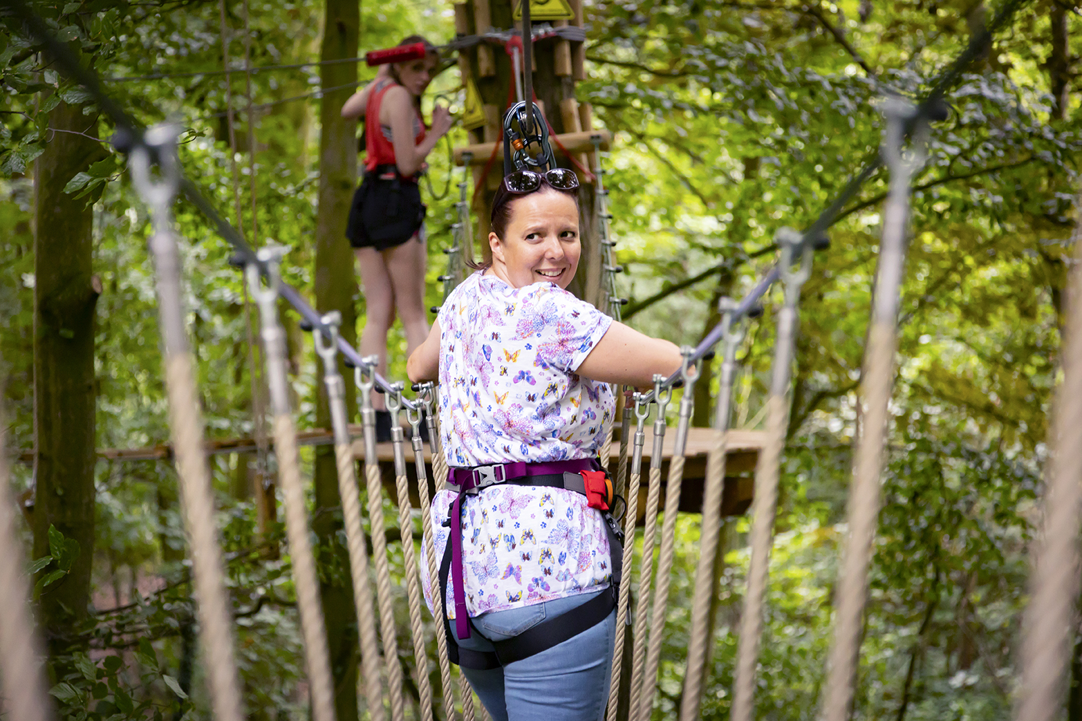 Person on a high ropes course wearing a harness.