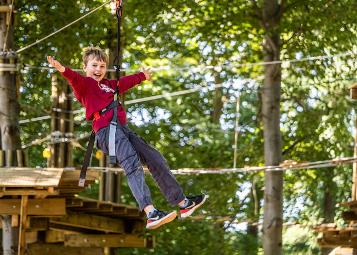 Young person on a zip wire with their arms wide.