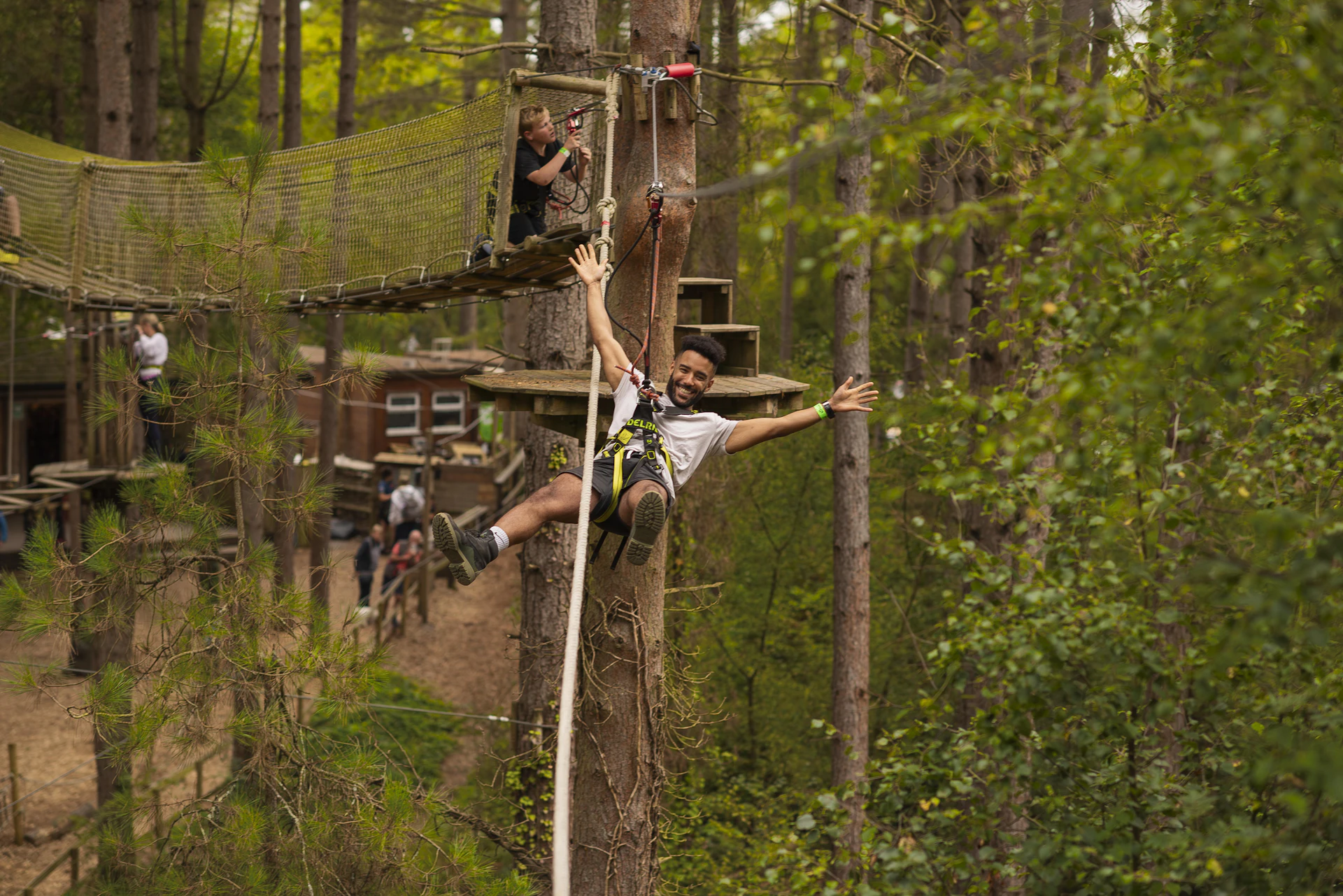 Person on a zip wire grinning with their arms wide.