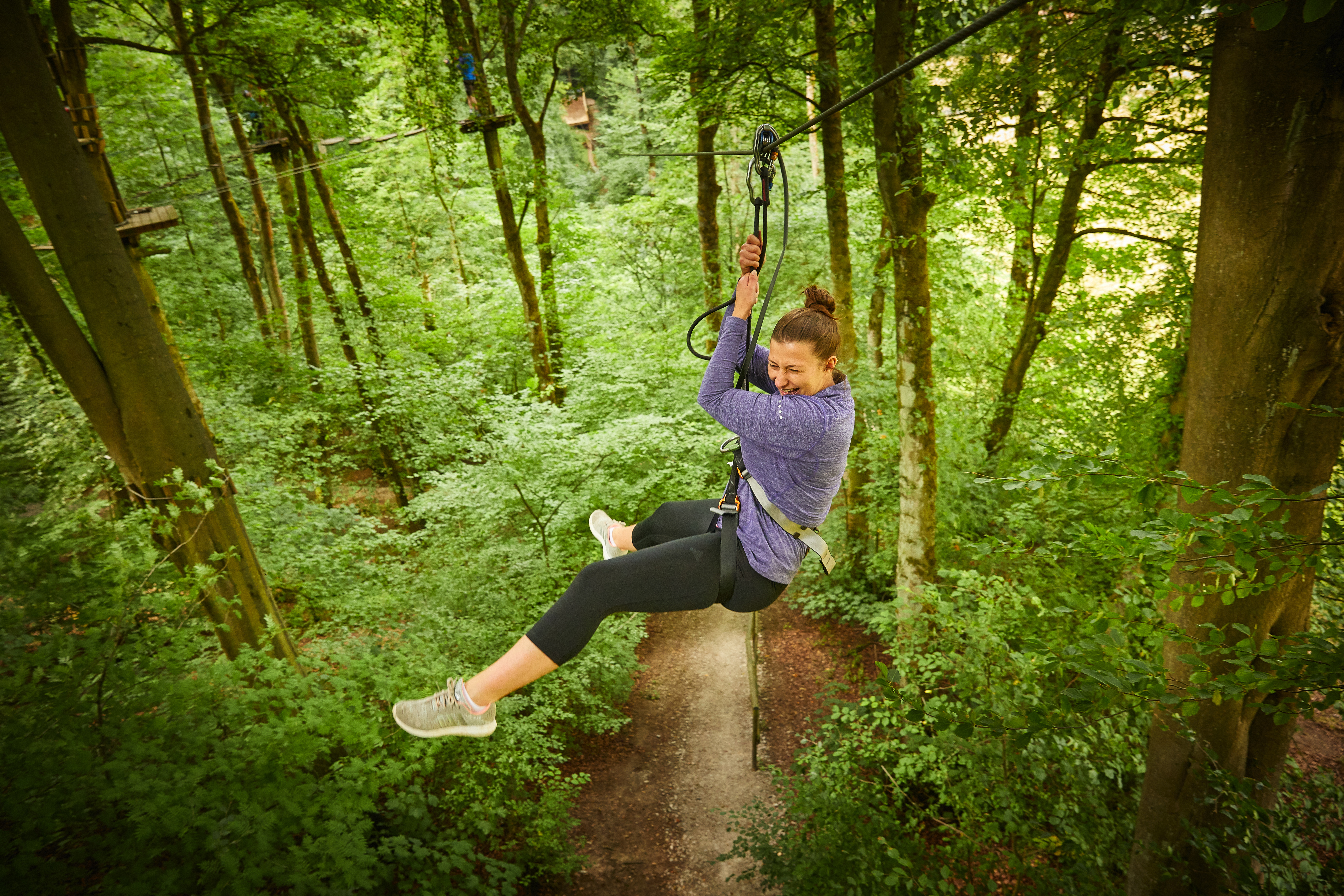 Person on a zipline while smiling.