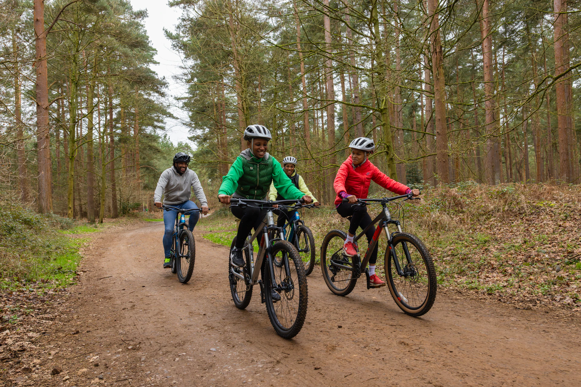 Adults and young people on a bike ride in the forest.