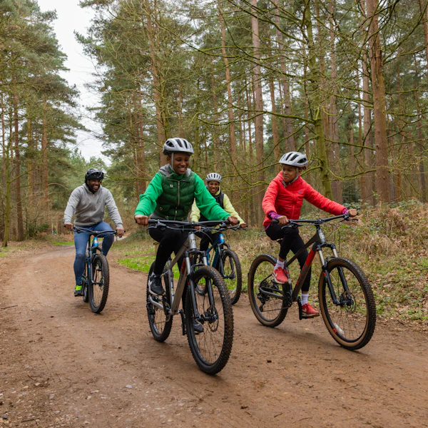 Adults and young people on a bike ride in the forest.