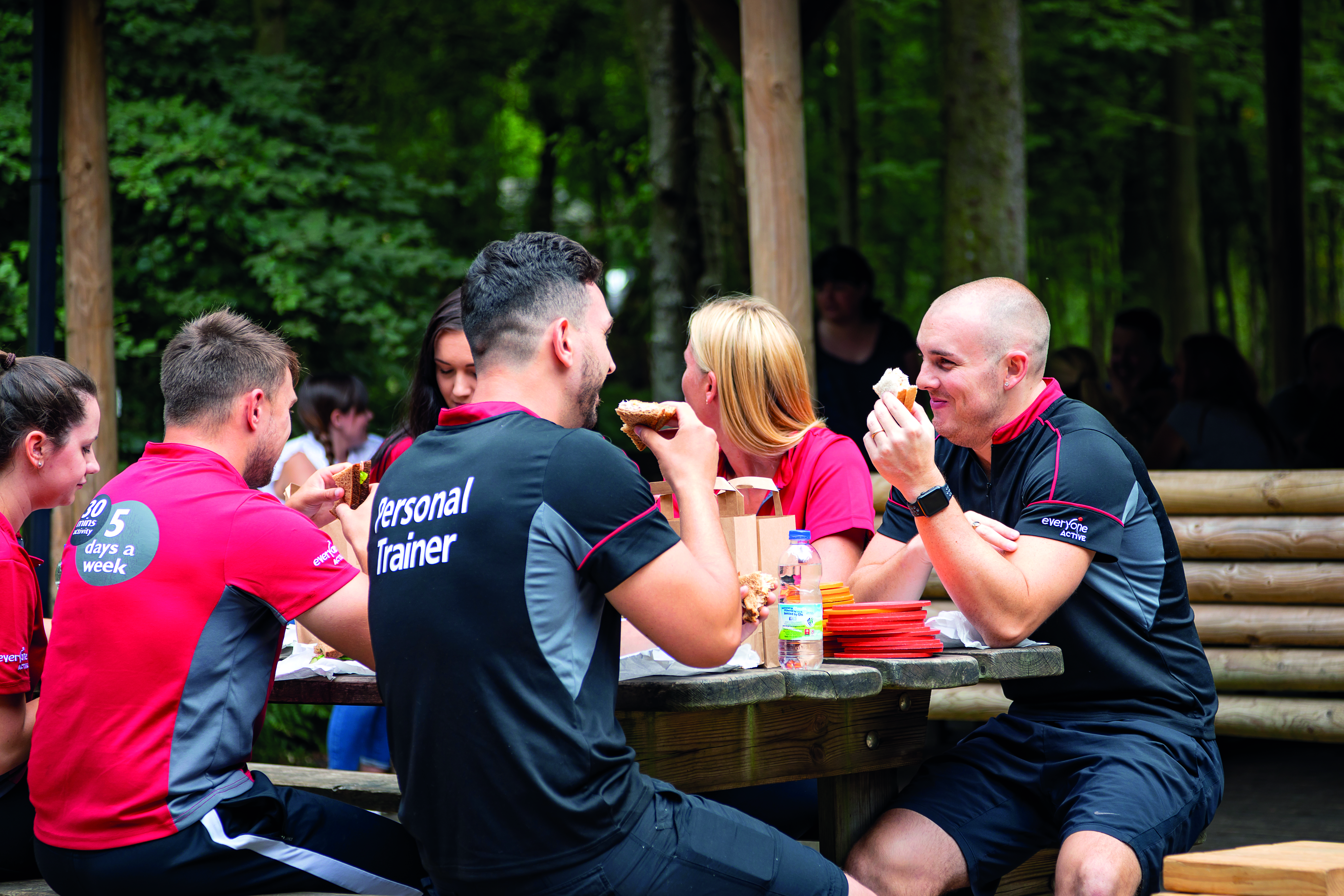 A group enjoy a meal in the Go Ape Forest Shelter