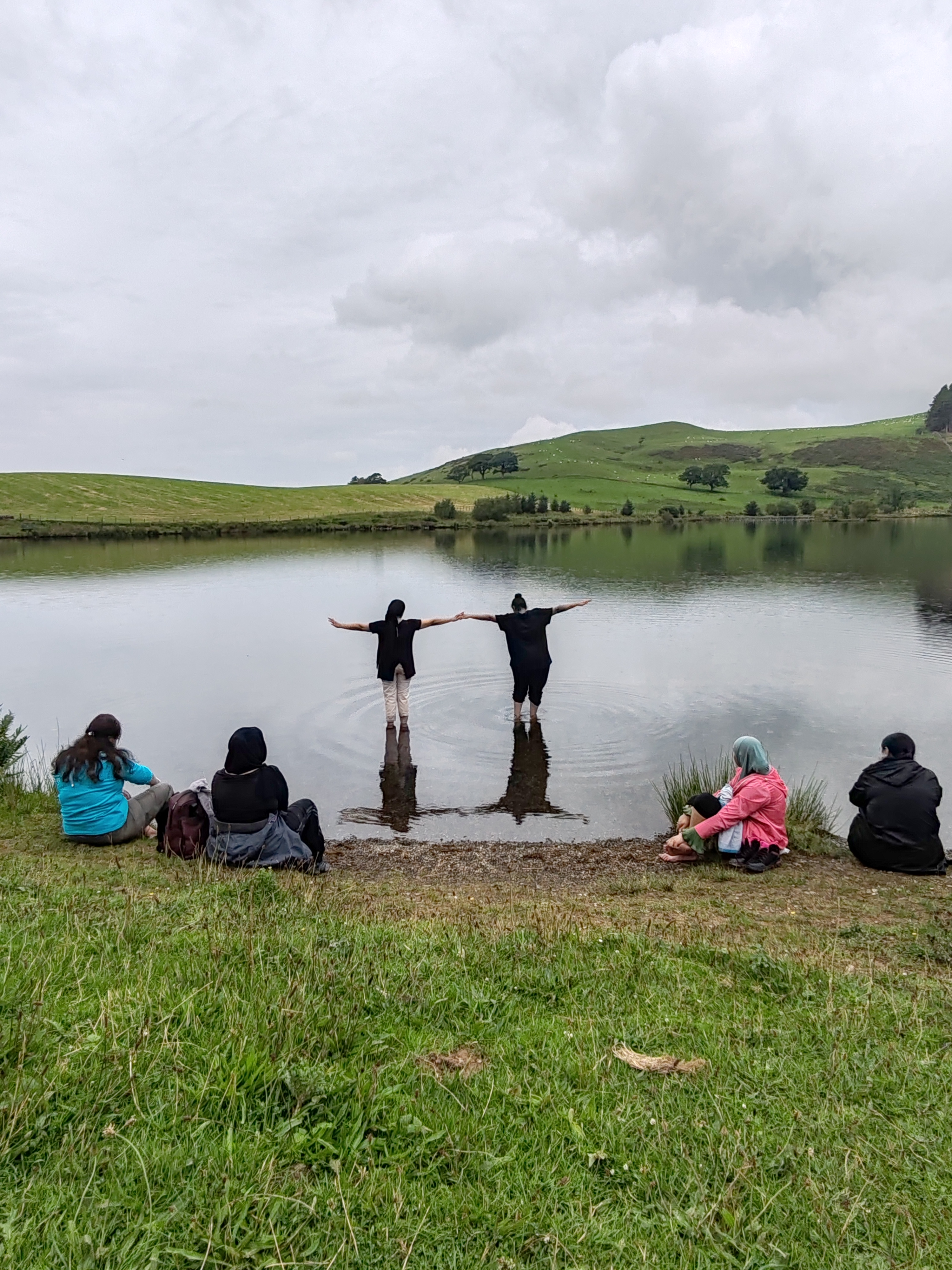 People resting by a lake and paddling.