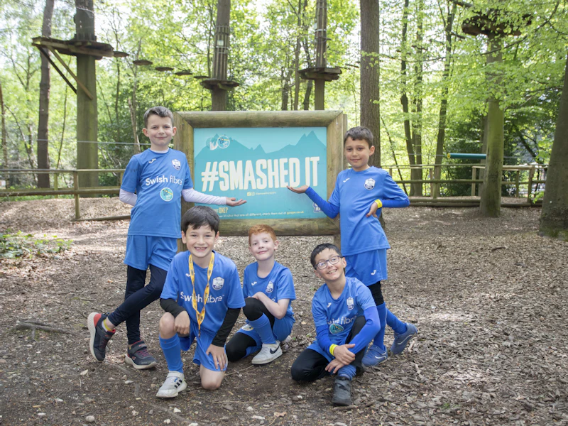 Group Smashed It Sign A group of young team mates celebrate their Go Ape visit by the #SmashedIt sign