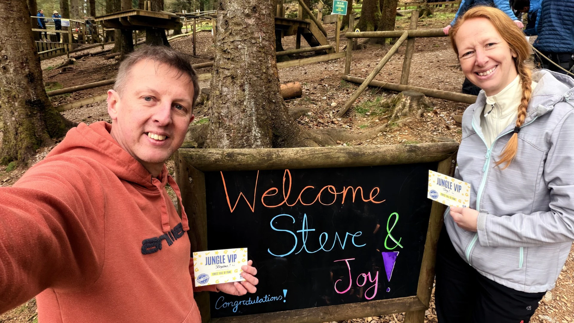 Two people by a sign reading 'Welcome Steve and Joy'