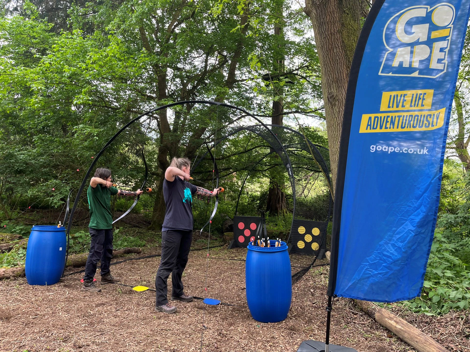 Two archers fire at targets during a Go Ape Archery Tag taster session