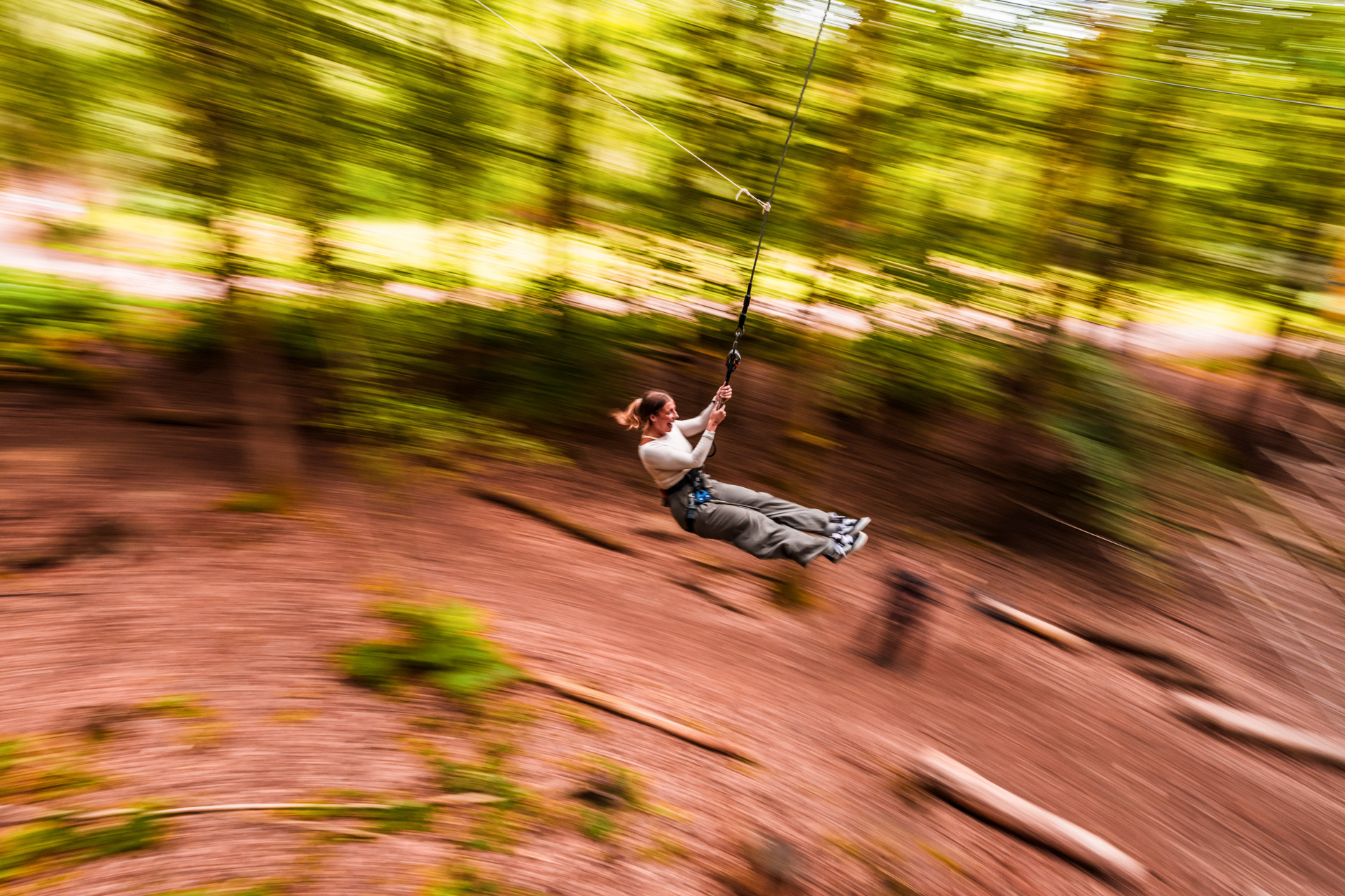 A woman rides a Tarzan Swing through the forest