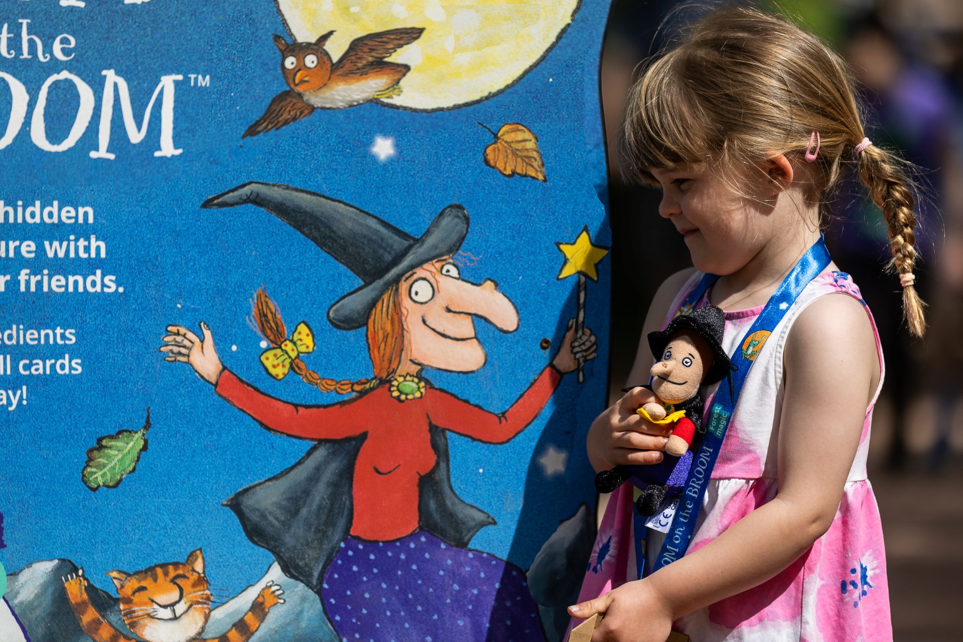 A small girl by a Room on the Broom trail sign